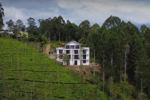 a white house on a hill in a field at Ophelia in Diyatalawa