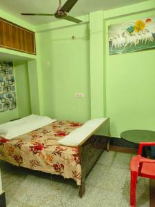 a bedroom with a bed and a ceiling fan at Rupali Guest House in Patna +23 photos