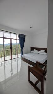 a bedroom with a bed and a large window at Ophelia in Diyatalawa