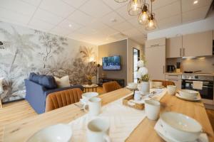 a kitchen and living room with a table and a couch at HYGGE HOMES - Apartment 'silva' in Winsen