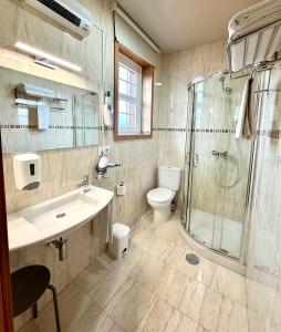 a bathroom with a sink and a shower and a toilet at Residencial Portas do Sol in Valença