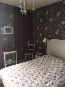 a bedroom with a bed with a quilt on it at Alice et Marie au Pays du Louvre in Lens