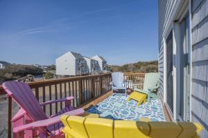a deck with chairs and a couch on a balcony at 4208 - Naan Sands in Duck