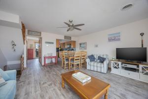 a living room with a couch and a tv and a table at 4208 - Naan Sands in Duck