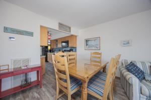 a dining room and kitchen with a table and chairs at 4208 - Naan Sands in Duck +21 photos