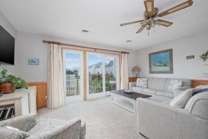 a living room with a couch and a ceiling fan at 4209 - Moby Duck in Duck