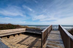 a wooden boardwalk to the beach with the ocean at 4220 - Timeless in Duck