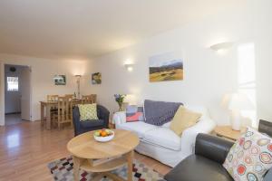 a living room with a white couch and a table at Manuka Cottage in Aviemore