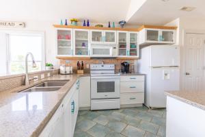 a kitchen with white cabinets and a white refrigerator at 4751 - Purple Passion in Kitty Hawk Beach