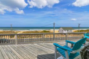 two blue chairs sitting on a deck looking at the beach at 4759 - Sun Daze in Kitty Hawk Beach