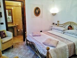 1 dormitorio con cama, silla y espejo en B&B Marina Piccola, en Vieste