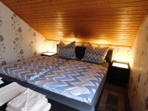 a bed in a room with a wooden ceiling at Ferienwohnung Schmitz in Welling