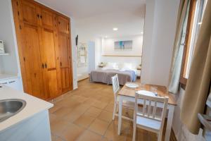 a kitchen with a table and chairs and a bedroom at Apartamentos Gravina in Tarifa