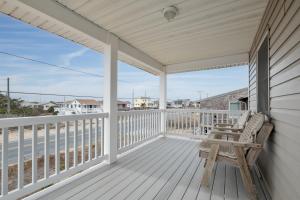 a wooden porch with a bench on a deck at 5061 - Good Night Irene in Kill Devil Hills