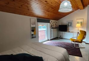 une chambre avec un lit et une chaise jaune dans l'établissement Bed&Breakfast Angela, à Clusone