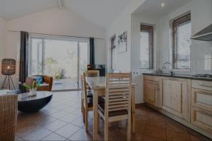 a kitchen with a table and chairs in a room at Huisje Britt met grote tuin en veel privacy in Dirkshorn