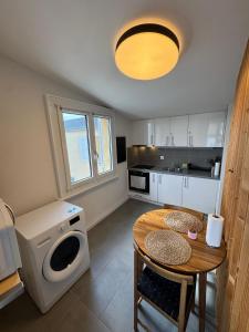 a kitchen with a table and a washing machine at Cosy attic flat Lausanne center in Lausanne