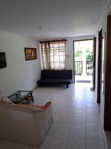 a living room with a couch and a tiled floor at Miss Leila in San Andrés