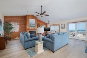 a living room with two blue couches and a ceiling fan at 5437 - WeekAway in Nags Head