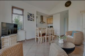 a kitchen and living room with a table and chairs at Huisje Britt met grote tuin en veel privacy in Dirkshorn