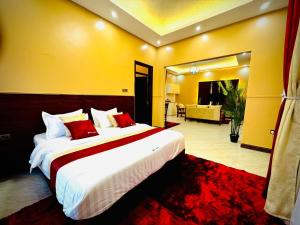 a bedroom with a large bed and a living room at Pieme Hotel Residence in Migade