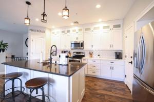 a kitchen with white cabinets and a large island with bar stools at Central Luxury Mountain Oasis with TWO Pools and Jacuzzis in Phoenix