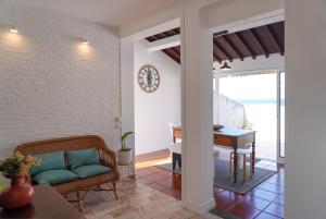 a living room with a couch and a piano at Canto 30 e UM - HOST & CHILL in Ribeira Grande