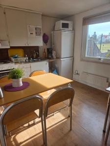 a kitchen with a table and a refrigerator at Alvaret Solhyddan in Köpingsvik