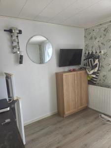 a living room with a tv and a mirror at Alvaret Solhyddan in Köpingsvik