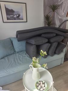 a couch with grey pillows and a table with flowers at Alvaret Solhyddan in Köpingsvik