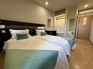 a hotel room with two beds in a room at Residencial Portas do Sol in Valença