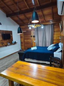 a bedroom with a blue bed and a wooden ceiling at Aconchego da Serra in São Joaquim