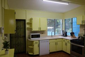 a yellow kitchen with yellow cabinets and a microwave at Villa Blue Nights in Saint James
