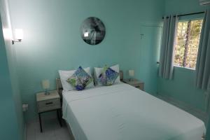 a bedroom with a white bed with a clock on the wall at Villa Blue Nights in Saint James +39 photos