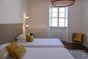 a bedroom with two beds and a window at Canto 30 e UM - HOST & CHILL in Ribeira Grande