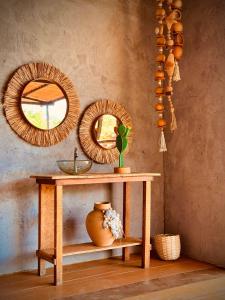 a table with two mirrors and a vase on it at Pousada Unaí - Casa Flor in Fernando de Noronha +48 photos