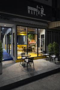 a group of tables and chairs outside of a restaurant at Free Way Kata Beach Hostel in Kata Beach