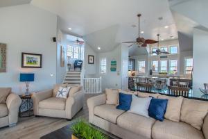 a living room with two couches and a dining room at 5469 - Below Deck OBX in Nags Head
