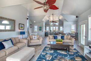 a living room with couches and a ceiling fan at 5469 - Below Deck OBX in Nags Head +38 photos