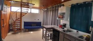 a kitchen with a spiral staircase and a blue chair at Perla Arenal View in Fortuna
