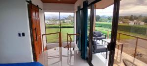 a room with a balcony with chairs and a view at Perla Arenal View in Fortuna
