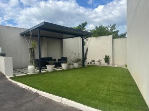 a patio with a green lawn in a yard at B&B Hotel Esikhaleni in eSikhawini +12 photos