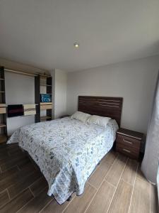a bedroom with a bed and a wooden floor at Apartamento en Parque Mateo in Guatemala