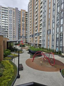 a playground in a park with tall buildings at Apartamento en Parque Mateo in Guatemala