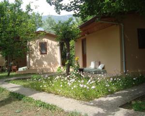 a small house with white flowers in the yard at 7 Garden Bungalow / Camping in Kumluca