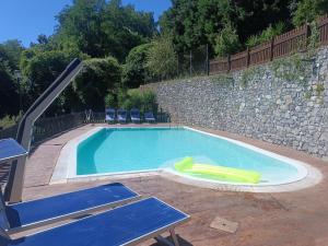a swimming pool with a slide in it at La Sorgente Apartment with private pool in Calice Ligure