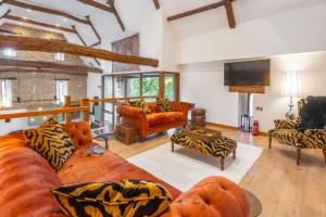 a living room with couches and a flat screen tv at Hillside Barn in Gimingham