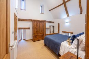 a bedroom with a blue bed and a wooden cabinet at Hillside Barn in Gimingham