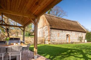 a patio with a table and chairs and a building at Hillside Barn in Gimingham