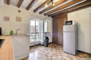a kitchen with a refrigerator and a window at Le Franche in Châtillon-sur-Loire +3 photos